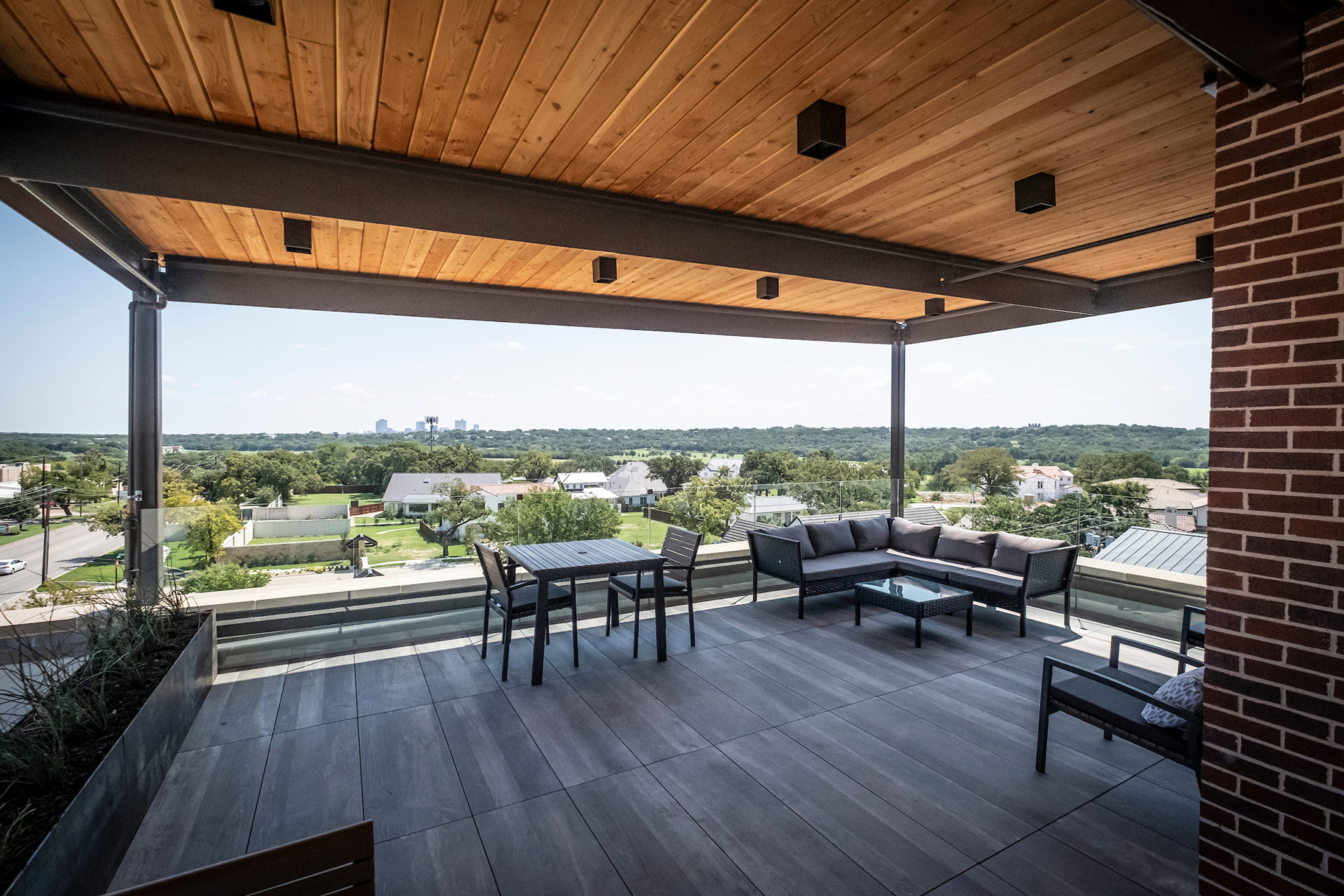 View of the rooftop balcony of 101 Nursery Lane with multiple seating arrangements and a view of downtown Fort Worth