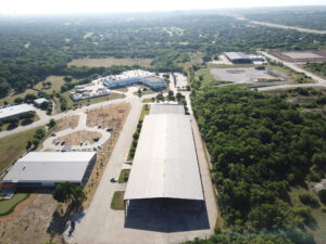 Aerial view of the silver roof of 7471 Benbrook Parkway showing the surrounding buildings and greenery in the background