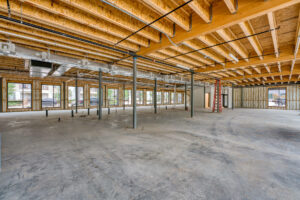 Interior view of 133 Nursery Lane with unfinished ceilings, cement flooring, and grey steel beams throughout the space