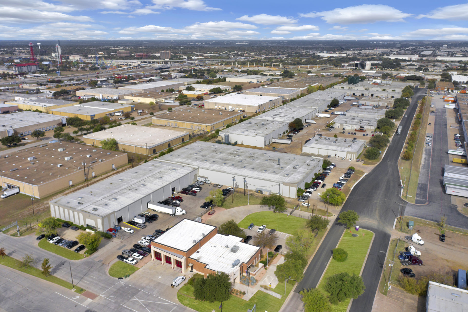 Aerial view of the Arlington Industrial Portfolio with one white, L-shaped building with many trucks and cars parked in front
