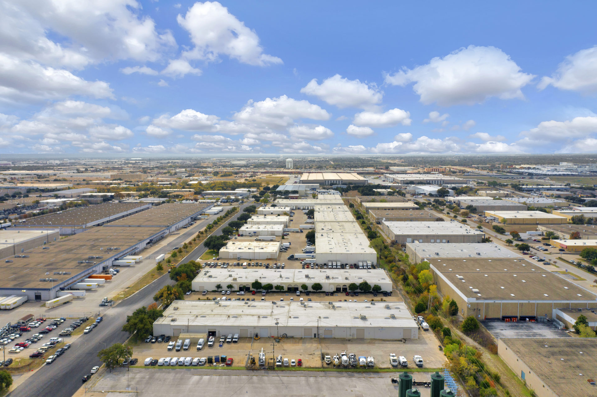 Birds eye view of the Arlington Industrial Portfolio of multiple white warehouse buildings on a contiguous plot of land